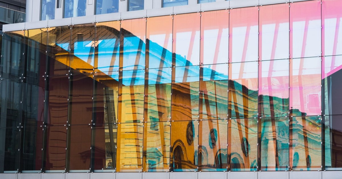 Glazen gevel van een modern kantoorgebouw met kleurrijke reflecties